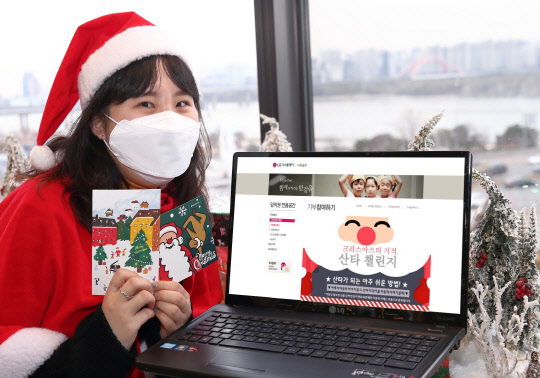 산타로 분장한 LG디스플레이직원이 아이들의 꿈을 응원하기 위해 제작한 엽서를 들고 있다. <LG디스플레이 제공>
